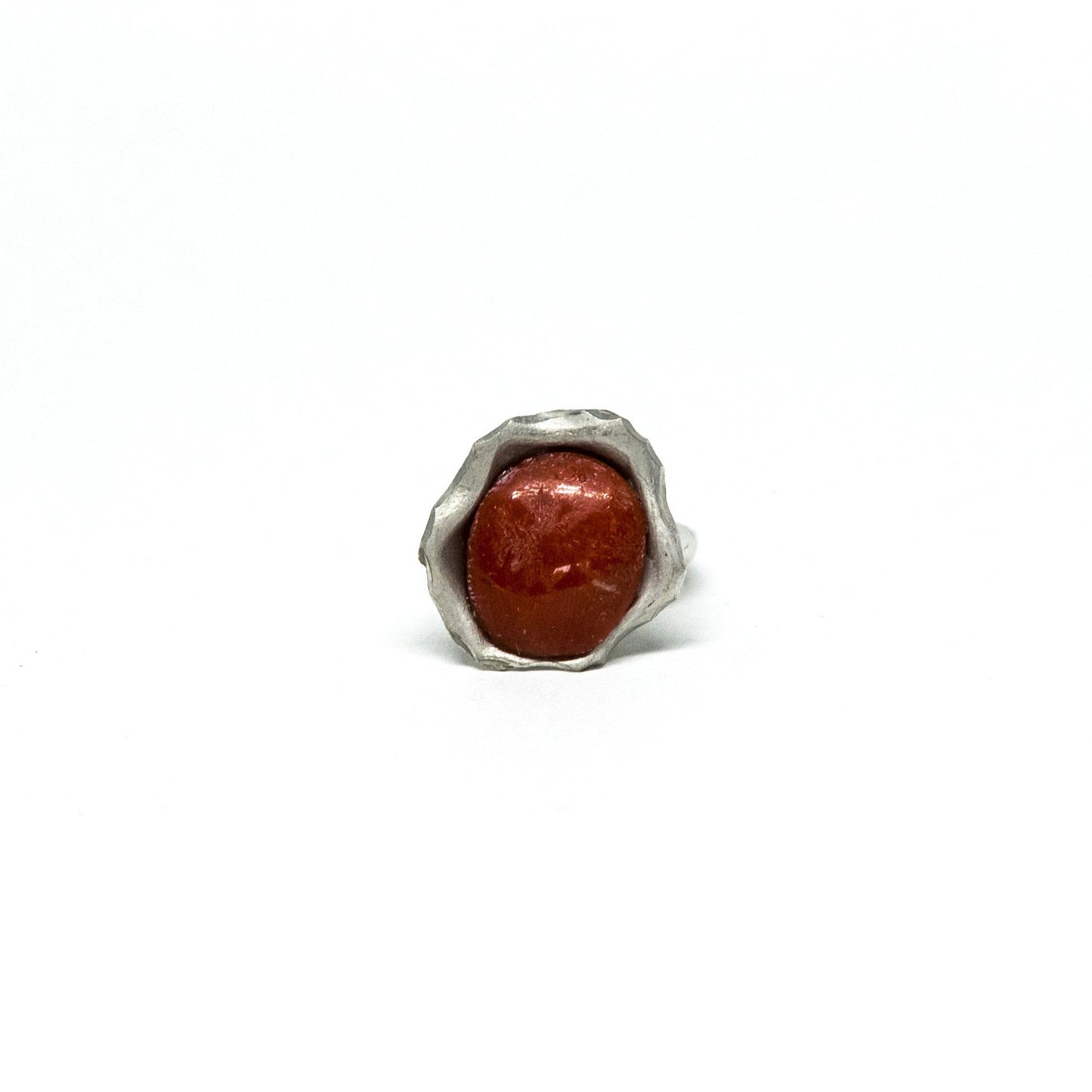 Anello in corallo rosso incorniciato da argento sbalzato