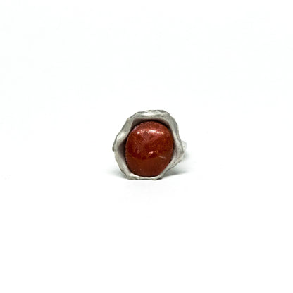 Anello in corallo rosso incorniciato da argento sbalzato